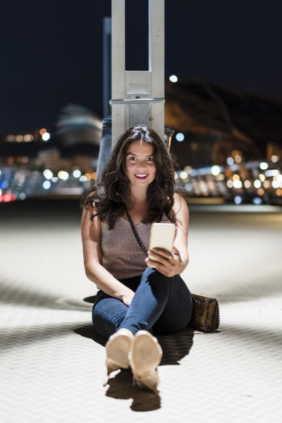 smiling woman with mobile phone sitting