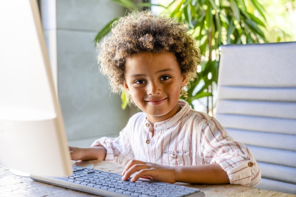 smiling cute boy with computer at