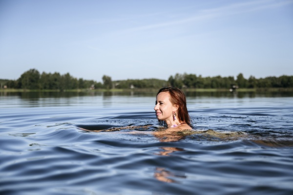 smiling woman enjoying swimming in lake